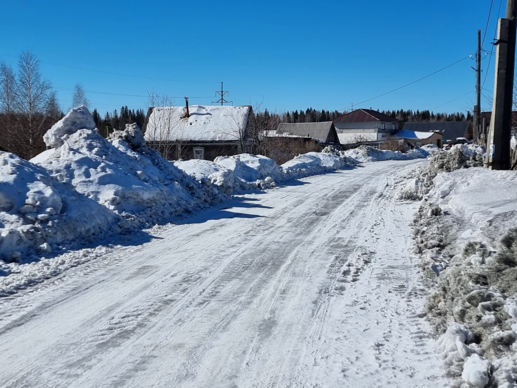 Снегогрязевая пульпа, сдвинутая с проезжей части, в частном секторе в жилой зоне в городе Качканаре