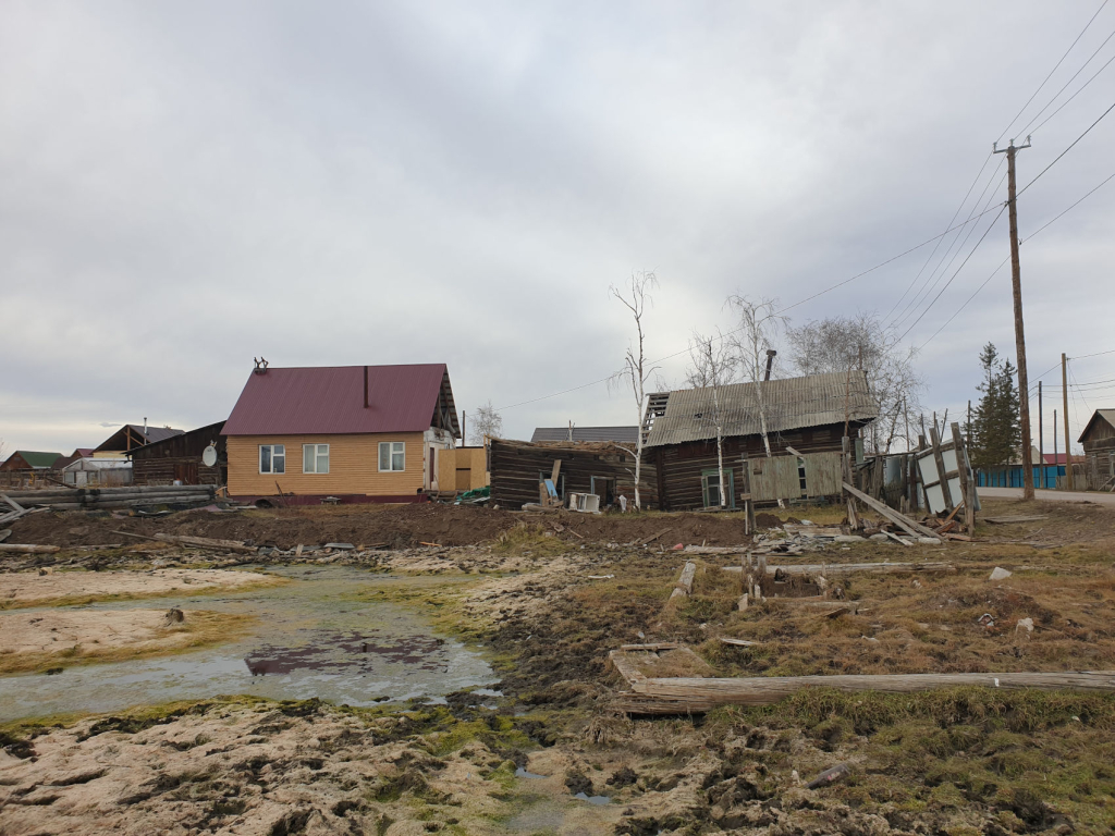 Заброшенный и новый дома на пострадавшем из-за деградации вечной мерзлоты участке в селе Амга, сентябрь 2021 г.