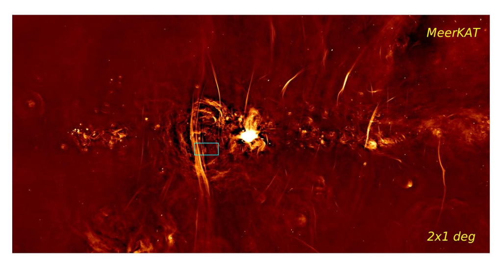 Карта радиоизлучения центральной зоны Галактики, полученная телескопом MeerKAT. Голубой прямоугольник — область, которая была подробно исследована рентгеновскими телескопами Chandra и IXPE (NASA). Группа ярких вертикальных линий/филаментов, проходящих через эту область, называется Аркой. Современные модели связывают такие структуры с движениями газа, формирующими топологию магнитного поля