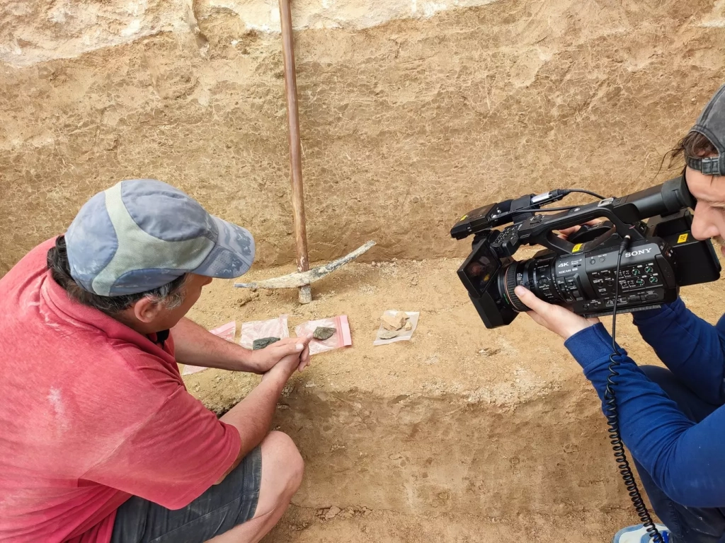Антон Анойкин показывает телевизионщикам находки с раскопа. Фото Алексея Паевского.
