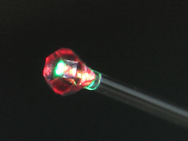 Флуоресцирующий кристалл алмаза, приклеенный к торцу оптического волокна.